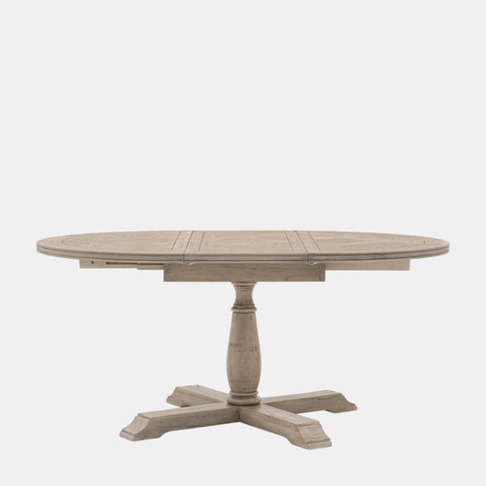 Round wooden dining table with a pedestal base on a white background