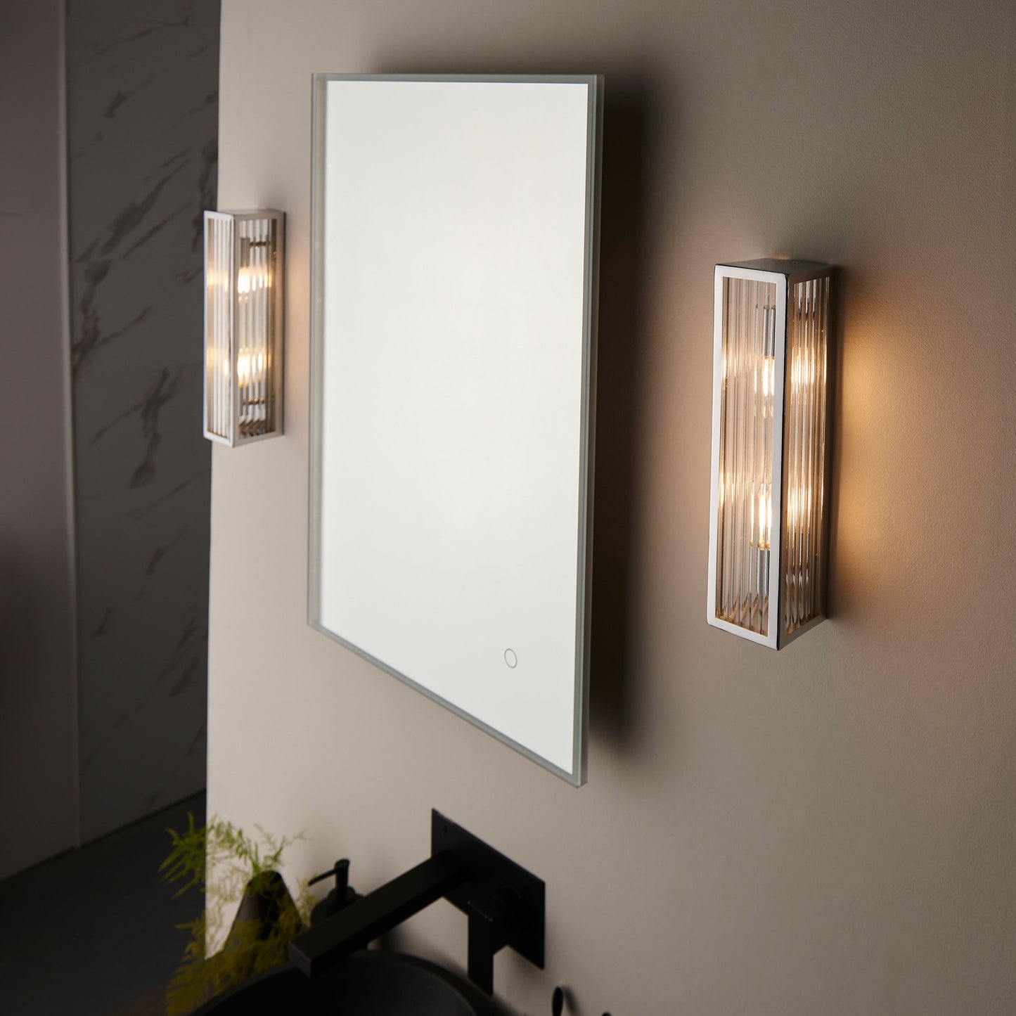 Bathroom mirror with two wall-mounted lights on a neutral wall.