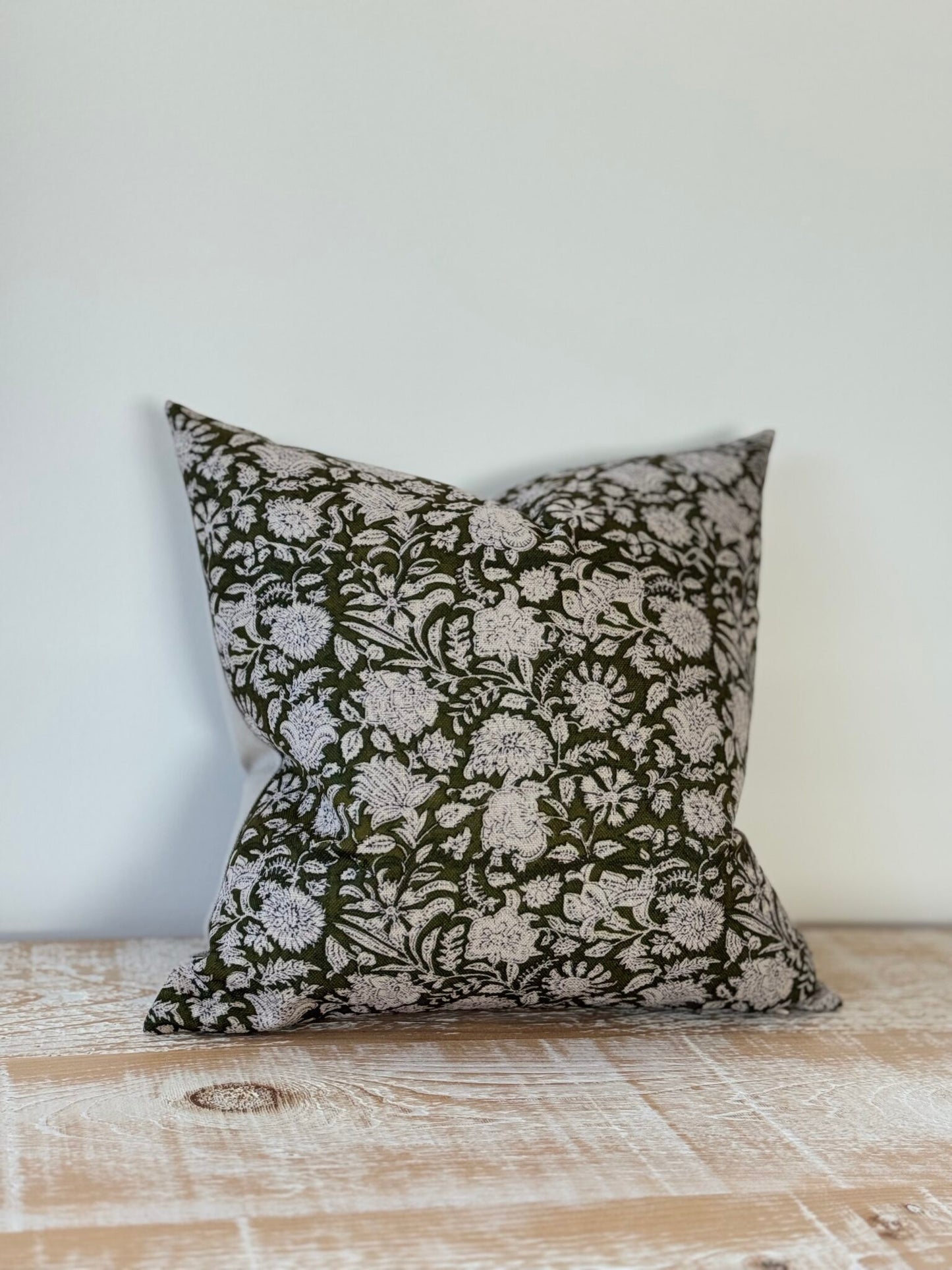 Decorative pillow with floral pattern on a wooden surface