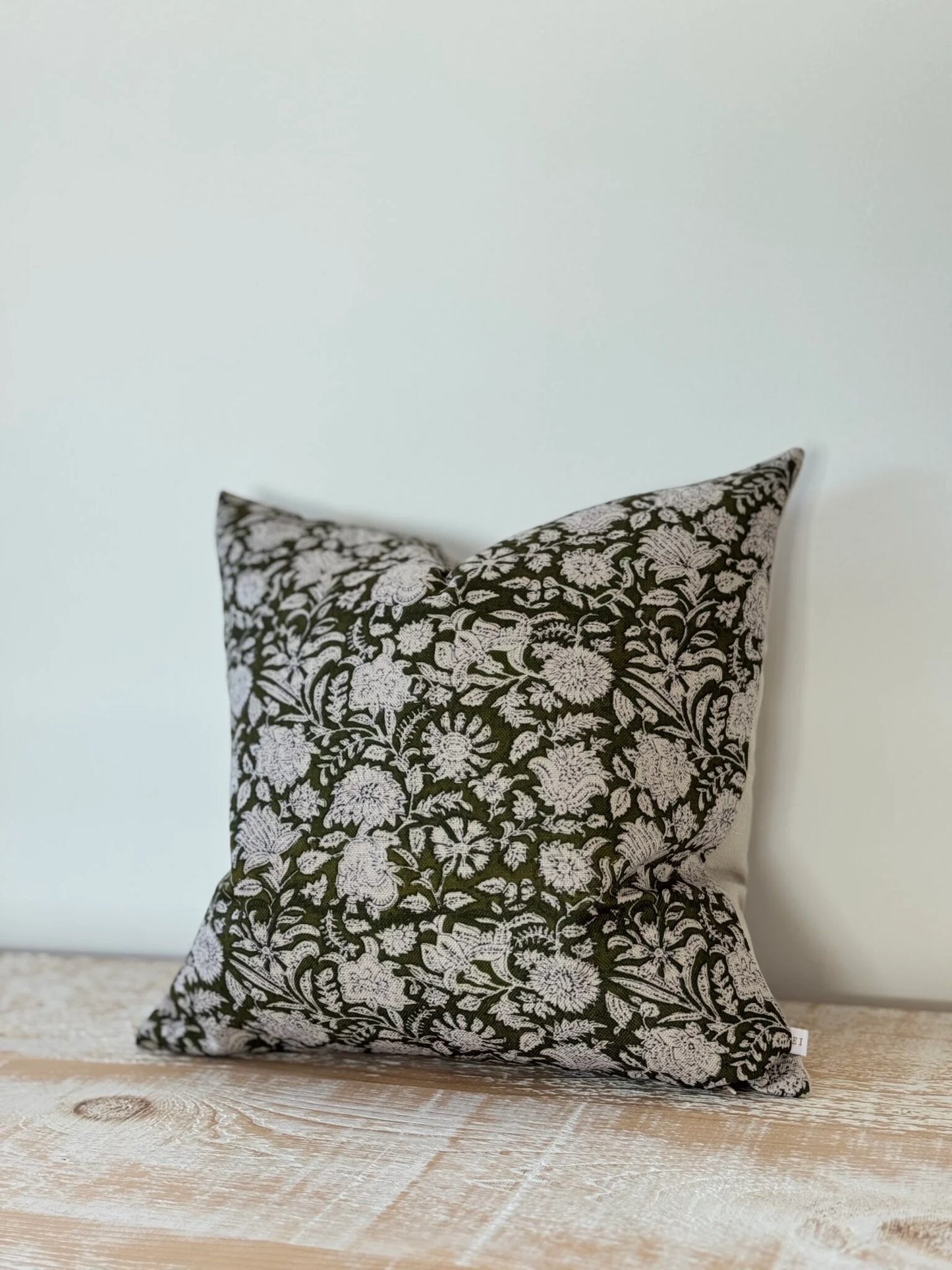 Decorative pillow with floral pattern on a wooden surface