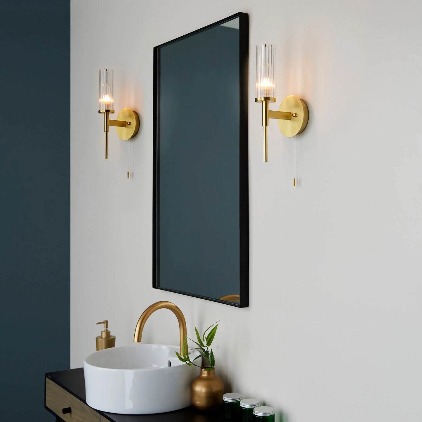 Bathroom with a mirror, sink, and wall lights on a neutral background