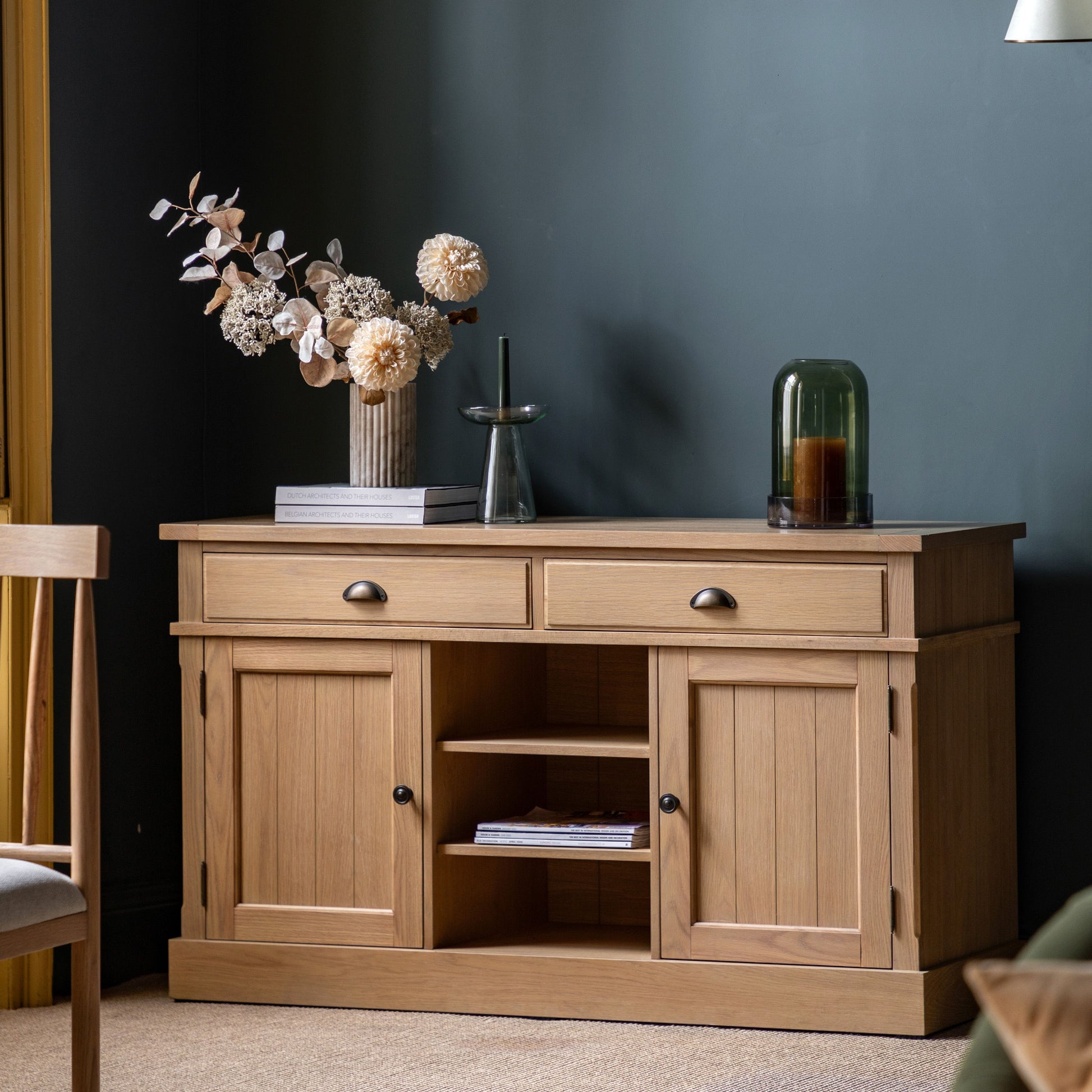 Wooden sideboard with decorative items against a dark wall
