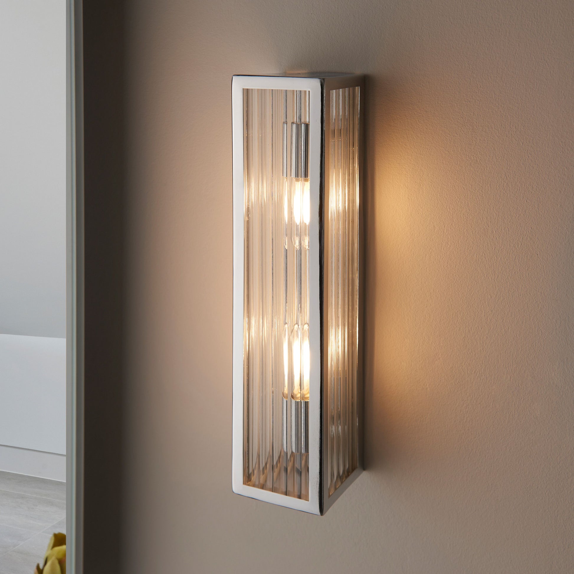 Wall-mounted light fixture with glass panel on a neutral wall