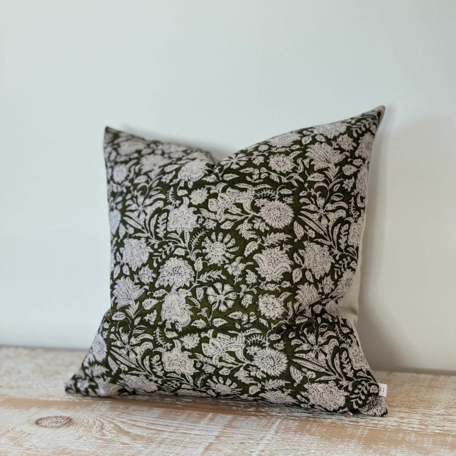 Decorative pillow with floral pattern on a wooden surface