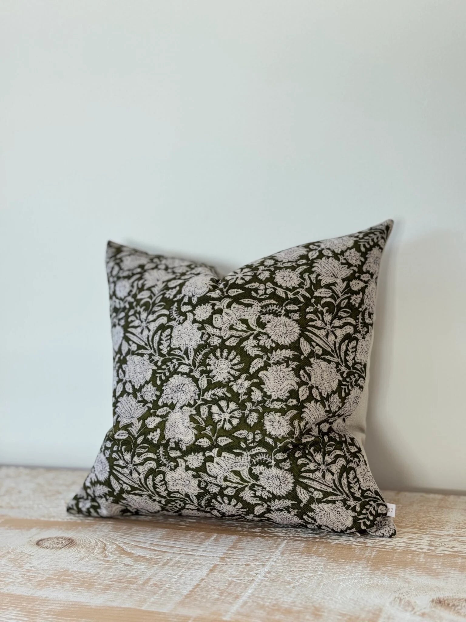 Decorative pillow with floral pattern on a wooden surface